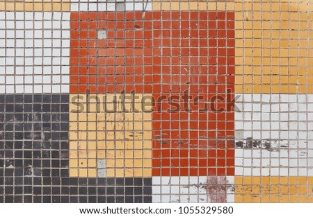Arranged rectangles of frayed ceramic tiles of red, yellow, dark and white.