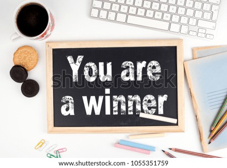 You are a winner. Chalkboard on white office desk