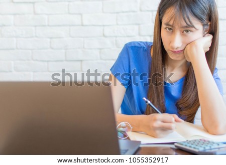 Beautiful asian woman is bored in front of her laptop when planning expenses of family,family concept.