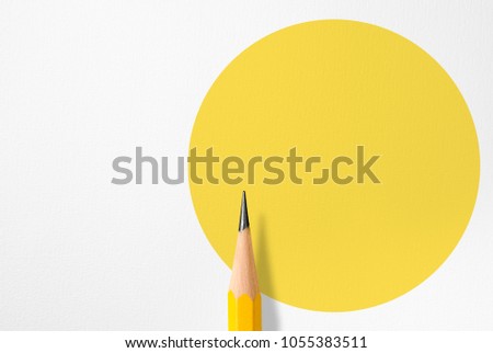 Minimalist template with copy space by top view close up macro photo of wooden yellow pencil isolated on white paper and combine with yellow circle shape. Flash light made smooth shadow from pencil.