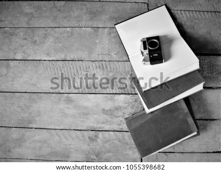 books with a briefcase and a camera on a wooden background