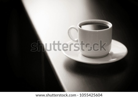 Cup of strong coffee on black table black and white photo.