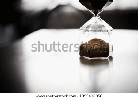 Hourglass showing time on the living room table. Time for investments. Business decisions made possible. Corporate financing is the future.