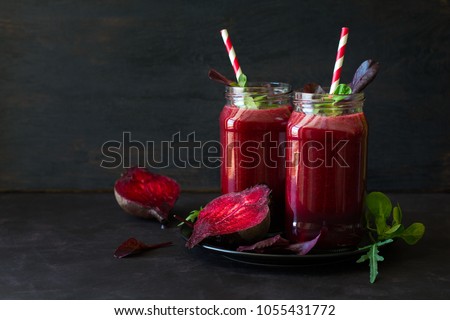Fresh beetroot smoothie, beet, arugula and lettuce leaves on dark wooden background Royalty-Free Stock Photo #1055431772