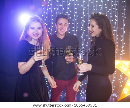 Three young men and two women  with glass champagne celebrate a birthday have fun in a nightclub at a party