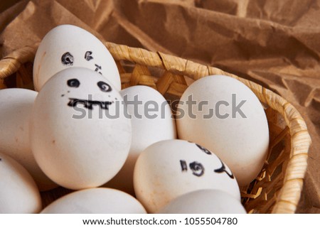 funny pictures on eggs in a basket, crumpled background            