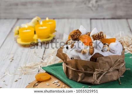 Easter cake (bread) decorated with candies, dried apricots and sunflower seeds on wooden background. Holidays concept