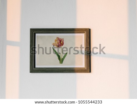 Flower photo frame hanging on white wall