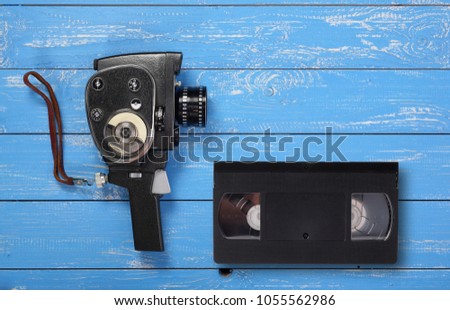 Vintage portable movie film camera Videotape VHS on a blue wooden background.