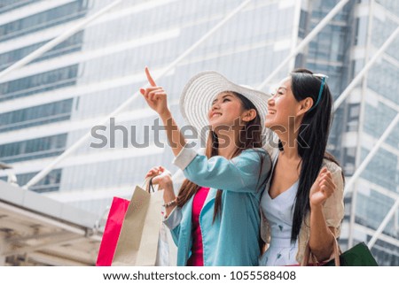 Happy business woman walking downtown shopping Shopping concept Buy a colorful shopping bag during the summer holidays in the mobile phone credit card sales of online.