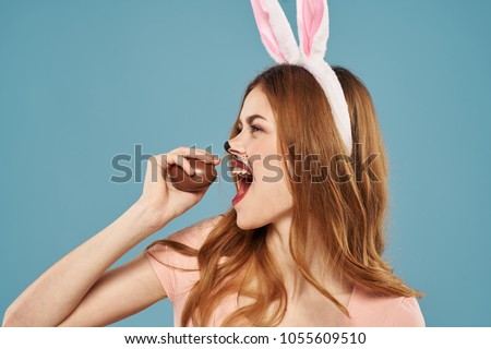 woman with chocolate egg on a blue background, easter, holiday                               