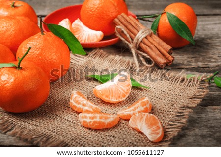 ripe juicy tangerine, orange mandarin with leaves on wooden table