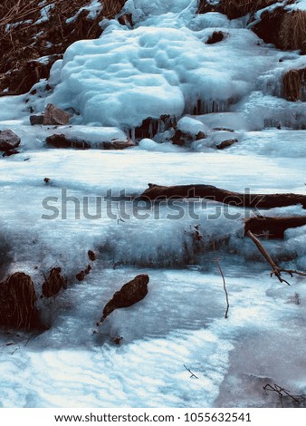 frozen waterfall flows over path