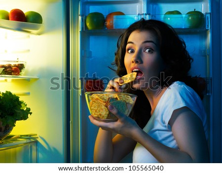 a hungry girl opens the fridge Royalty-Free Stock Photo #105565040