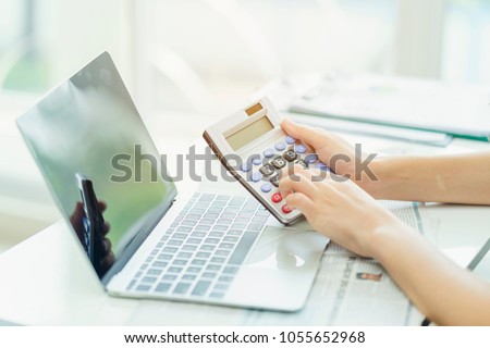 Accounting analyst calculate break even point by using financial report for banking investment. Using calculator and computer laptop to collect financial data to analyse profit for executive decision Royalty-Free Stock Photo #1055652968