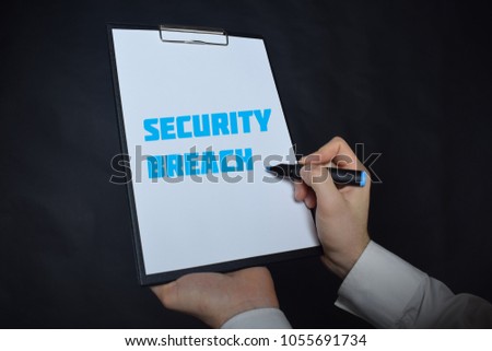 In the hands of a businessman a notebook with the inscription:SECURITY BREACH