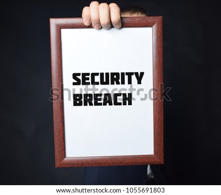 In the hands of a businessman a frame with the inscription:SECURITY BREACH