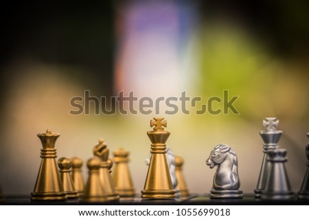 Gold and silver King and Knight of chess battle on board . Gold king are leader to fight with teamwork to victory.  Leader and teamwork concept for success.