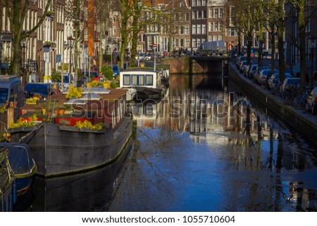 Beautiful outdoor view of houses and Boats on Amsterdam Canal with frozen river, morning photo of colored houses in the Dutch style with reflection in water
