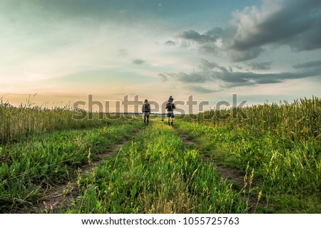 Family walks on the field at sunset Royalty-Free Stock Photo #1055725763