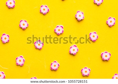 pattern of flower toppings on yellow paper background. spring concept.