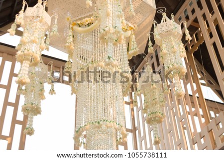 Thai traditional garland chandelier are swaying slowly in the breeze. This picture has footage also.