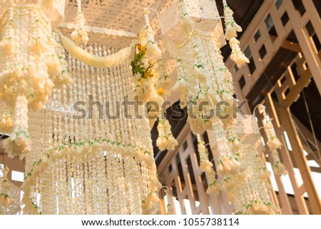 Thai traditional garland chandelier are swaying slowly in the breeze. This picture has footage also.