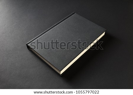 Blank book cover on black paper background.