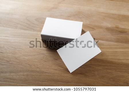 Mockup of blank business cards on wood background.