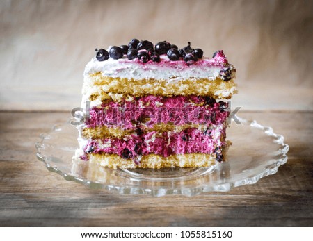 Piece of blueberry cake on wooden table vith black vignete.