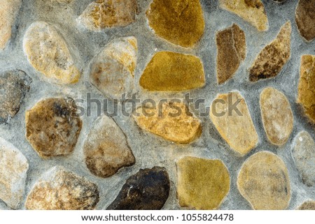 Amazing background of textured river stones laid out on a cement mortar