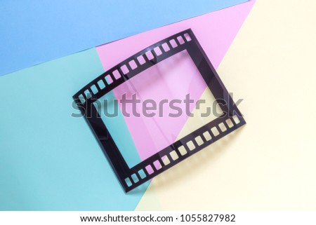 Retro negative film blank photo frame on colorful pastel background minimal creative concept.