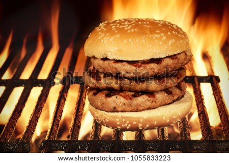Homemade King Size Hamburger Or Cheeseburger On BBQ Flaming Grill Isolated On Black Background. Concept For Party Cookout Food.