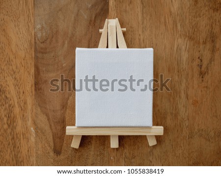 wooden easel on wooden background. Flat lay