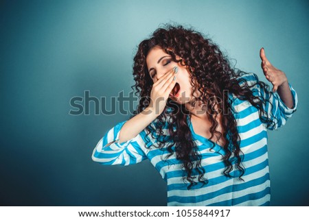 It is too early for me. Closeup portrait sleepy young woman with wide open mouth yawning eyes closed looking bored isolated blue wall background. Face expression emotion body language