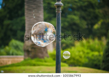 Soap bubble floating in the air on the natural forest background with a nice slightly swirly bokeh