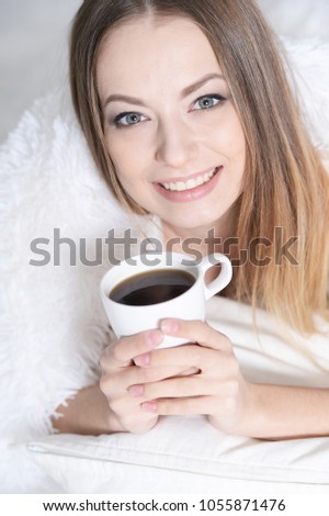 beautiful woman with a cup of tea on sofa