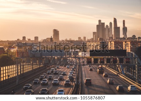 Summer evening cityscape photography of Moscow city with car traffic and amazing sunset above wide road with many cars and modern skyscrapers, Russia outdoor landscape