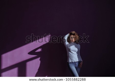 curly girl in a turtleneck on a purple background.