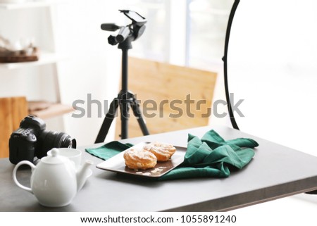 Professional camera and food composition on table in photo studio