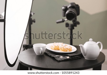 Professional camera on tripod and food composition in photo studio