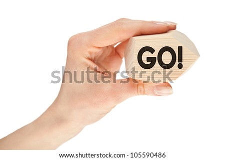 Human hand holding wooden block with inspiring text "GO!" isolated on white