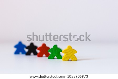 Colorful wooden people figures at white background symbolizing team work and diversity