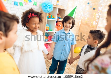 Group of happy children dancing round dance on birthday party. Concept of children's holiday. Happy children have fun on celebration.