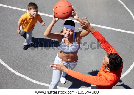 Cheerful family of three playing amateur basketball