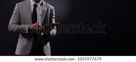 Full Length Snap Figure, Business Man Stand in gray Suit white shirt black pants shoes, studio lighting dark background, Asian Male Model happy smile with mobile smart phone tablet, low key exposure