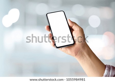 Closes up of an unrecognizable businessman hand holding smartphone on abstract bokeh background