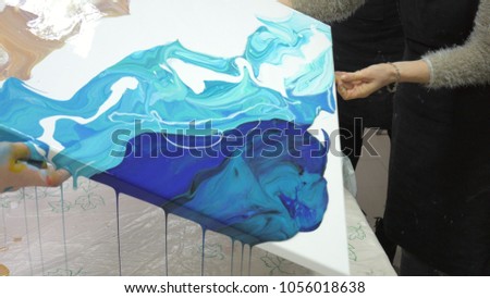 woman draws a picture of a fluid art on canvas 4k