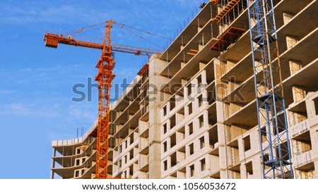 Construction site with crane and building. Construction crane near concrete building.