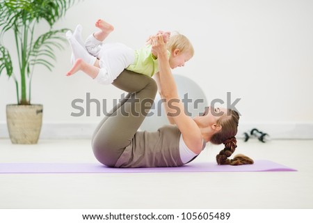 Healthy mother and baby making gymnastics Royalty-Free Stock Photo #105605489